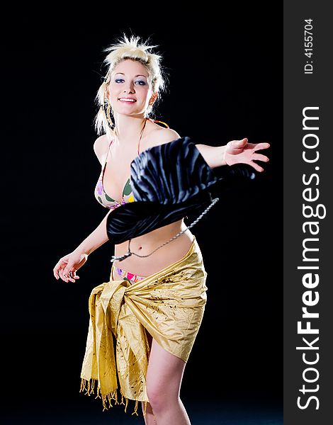 Woman throwing a cowboy hat happily with gold scarf wrapping her hips. Woman throwing a cowboy hat happily with gold scarf wrapping her hips