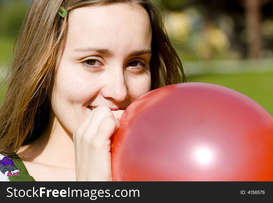 Young Woman Inflating Red Balloon