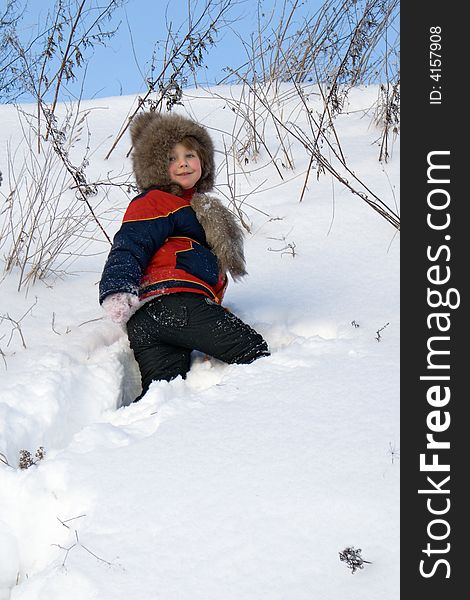 The young girl climbs on a snow-covered hill