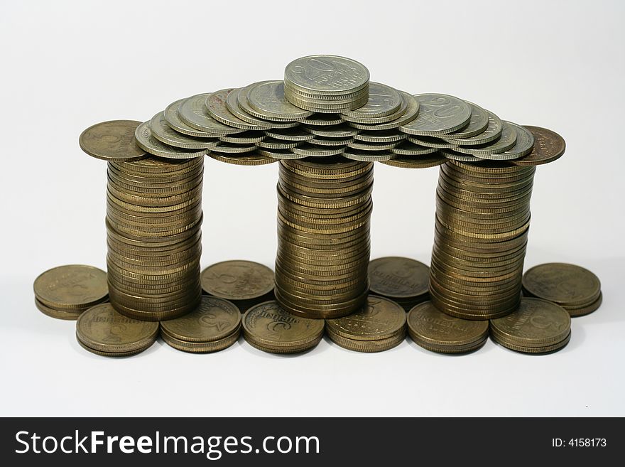 Close-up of multicolor coins making as a house on the white background (isolated on white). Close-up of multicolor coins making as a house on the white background (isolated on white)