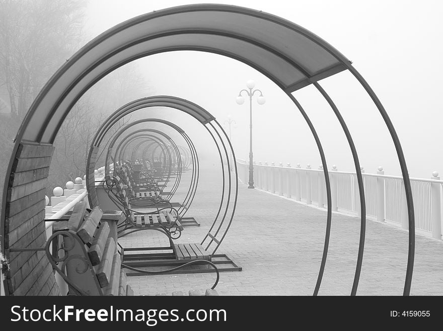 Sea-front in a fog, the benches creating the tunnel