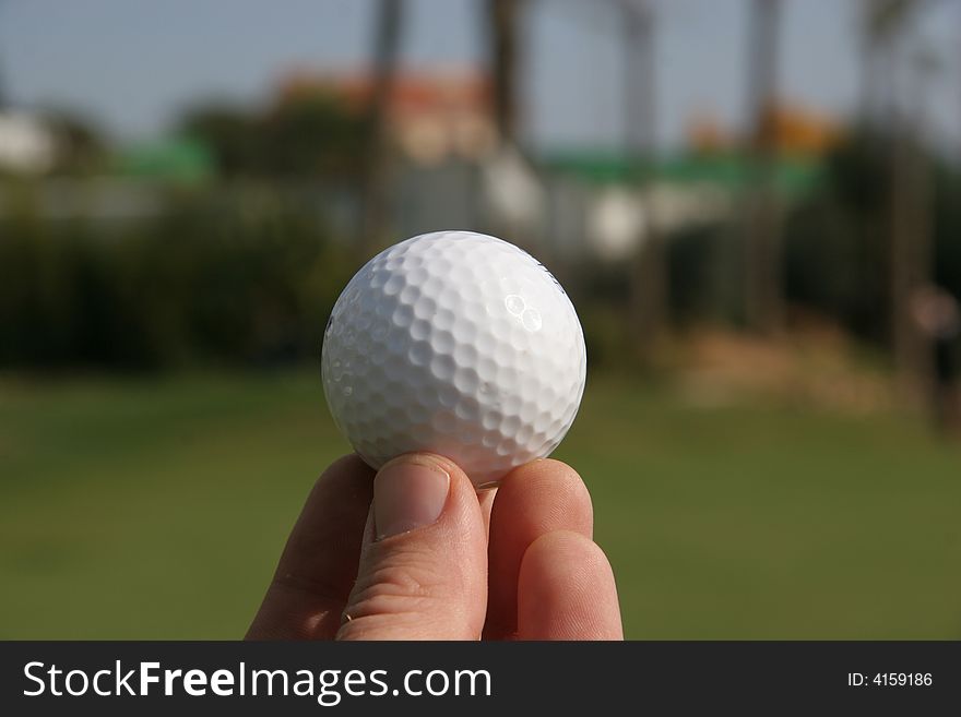 A golf ball in the hand of a golfer. A golf ball in the hand of a golfer