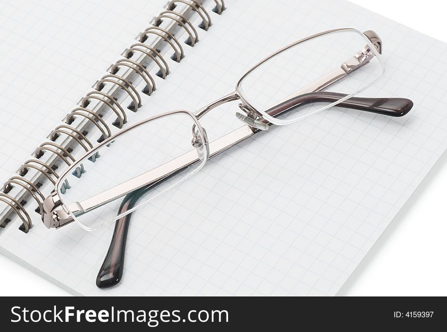 Eyeglasses on spiral notepad isolated on white