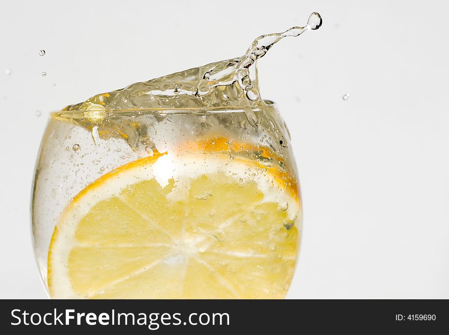 Splash, water drops and an lemon in water
