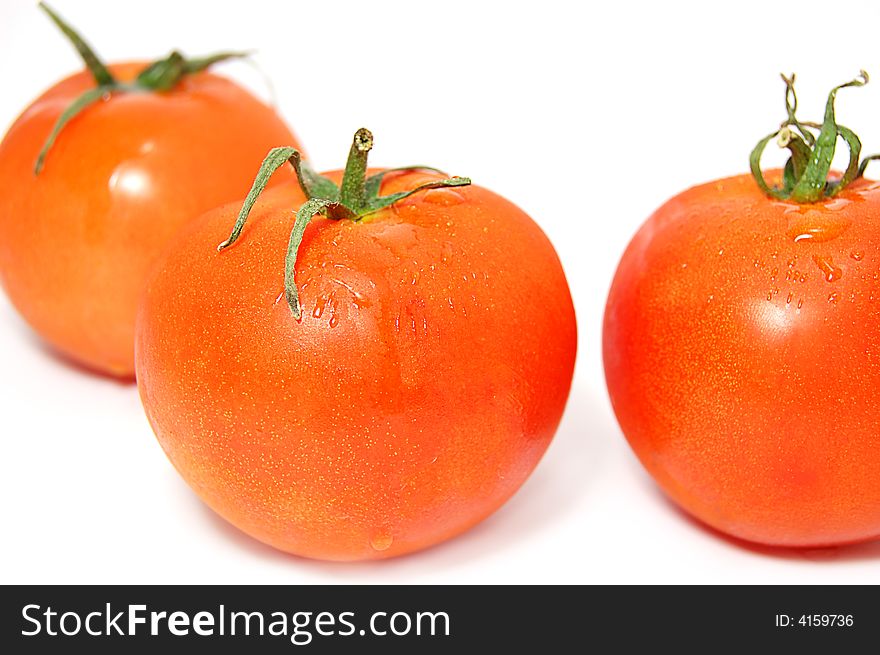 Three ripe red tomatos with green ends isolated on white. Three ripe red tomatos with green ends isolated on white