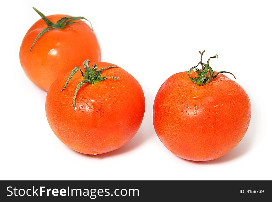 Three ripe red tomatos with green ends isolated on white. Three ripe red tomatos with green ends isolated on white