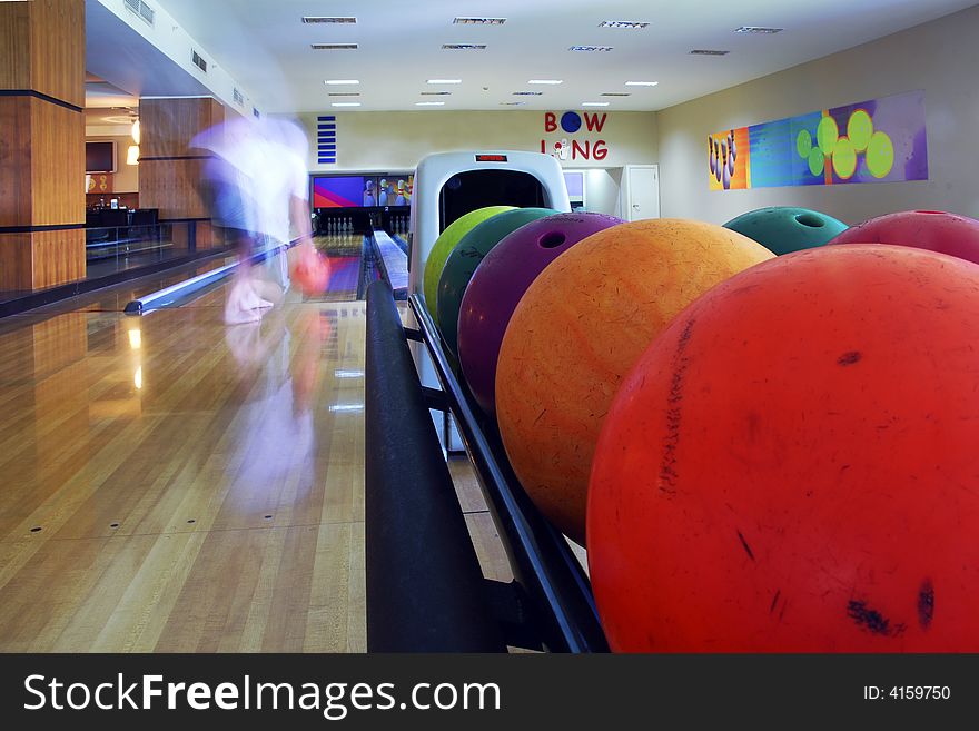 Close-up of the colored bowling balls and man