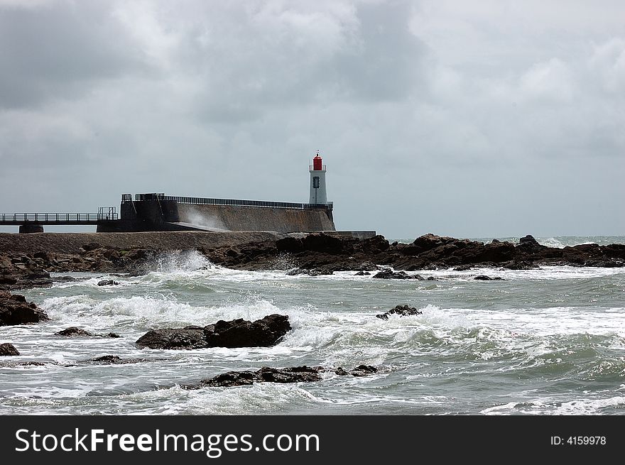 Wave breaking against the rocks near the lighthouse