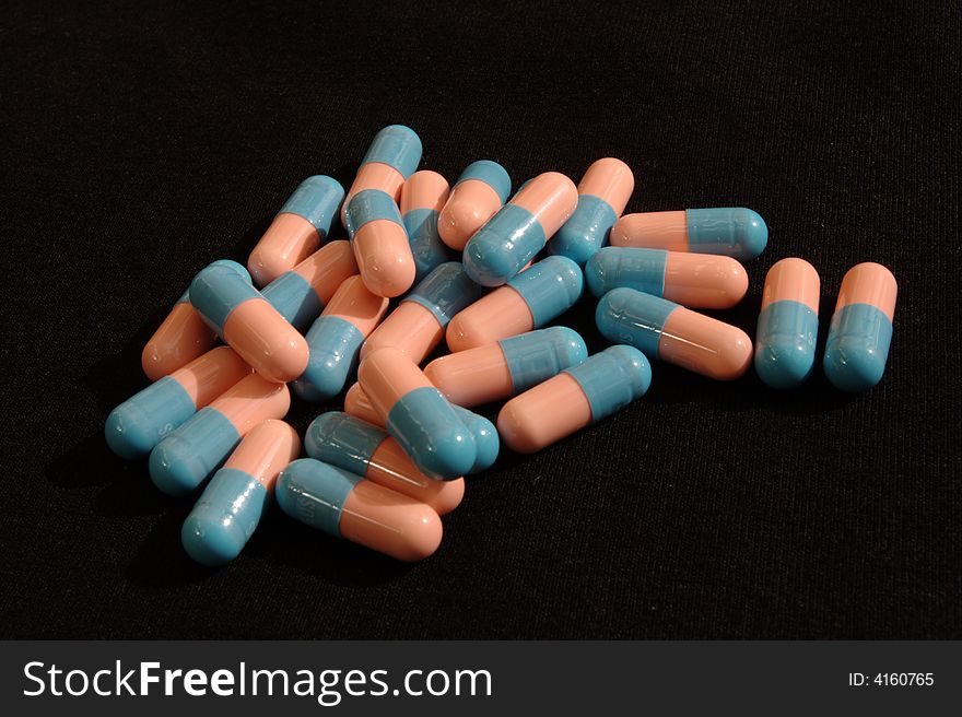 Pink and blue capsules in a pile.