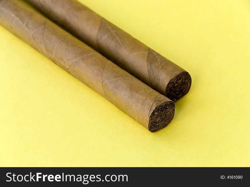 2 Cigars On The Yellow Background