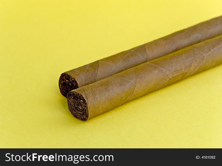 2 cigars on the yellow background.
