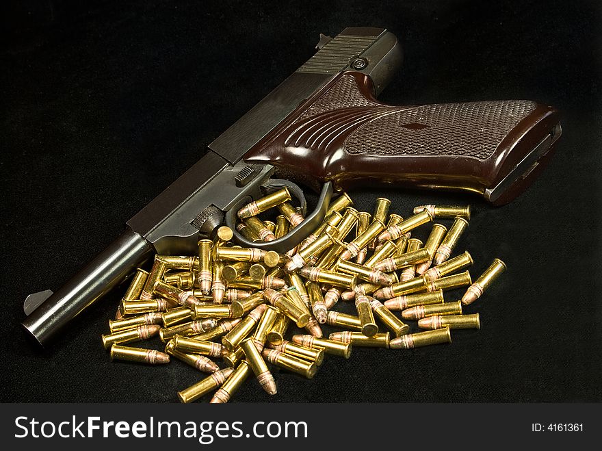 A shot of a old army pistol and a pile of ammo. A shot of a old army pistol and a pile of ammo.