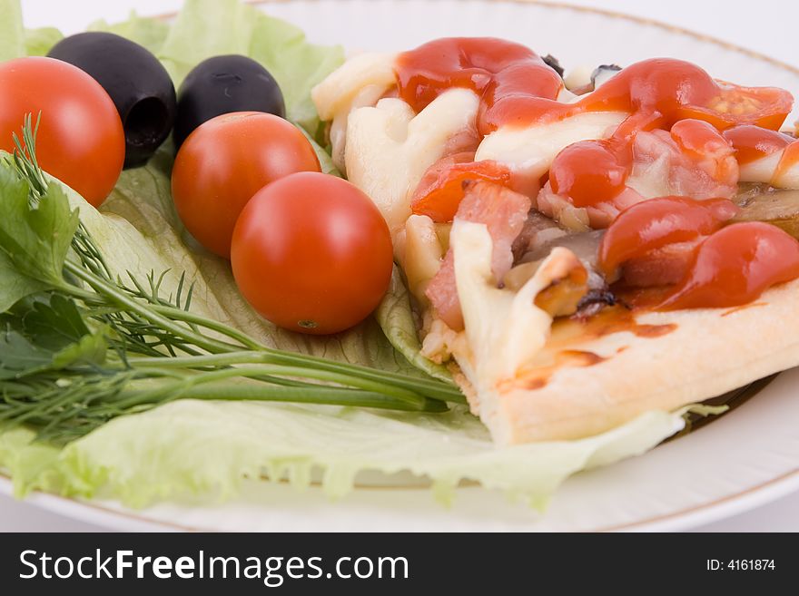 Piece of a pizza with vegetables on a plate on a white background (close up)