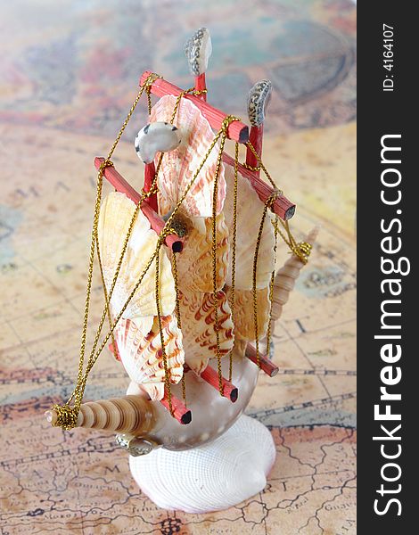 Sailing ship made from seashells over old map. Sailing ship made from seashells over old map