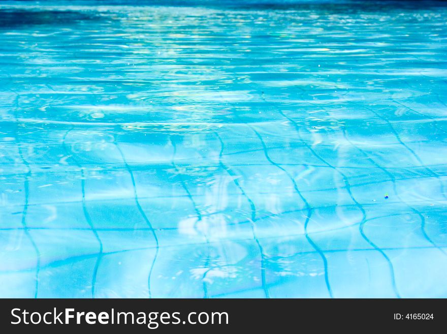 Peaceful blue swimming pool water at a tropical resort. Peaceful blue swimming pool water at a tropical resort