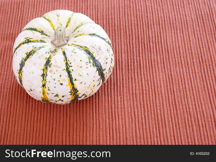 White striped pumpkin on cloth background. White striped pumpkin on cloth background.