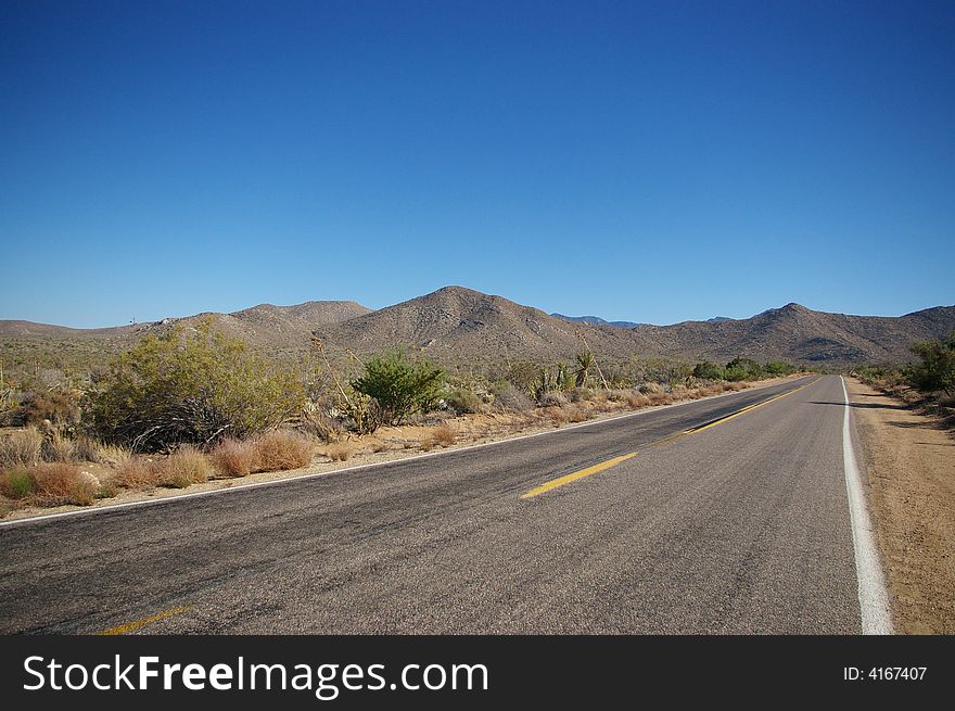 An empty road in the middle of the California desert.
