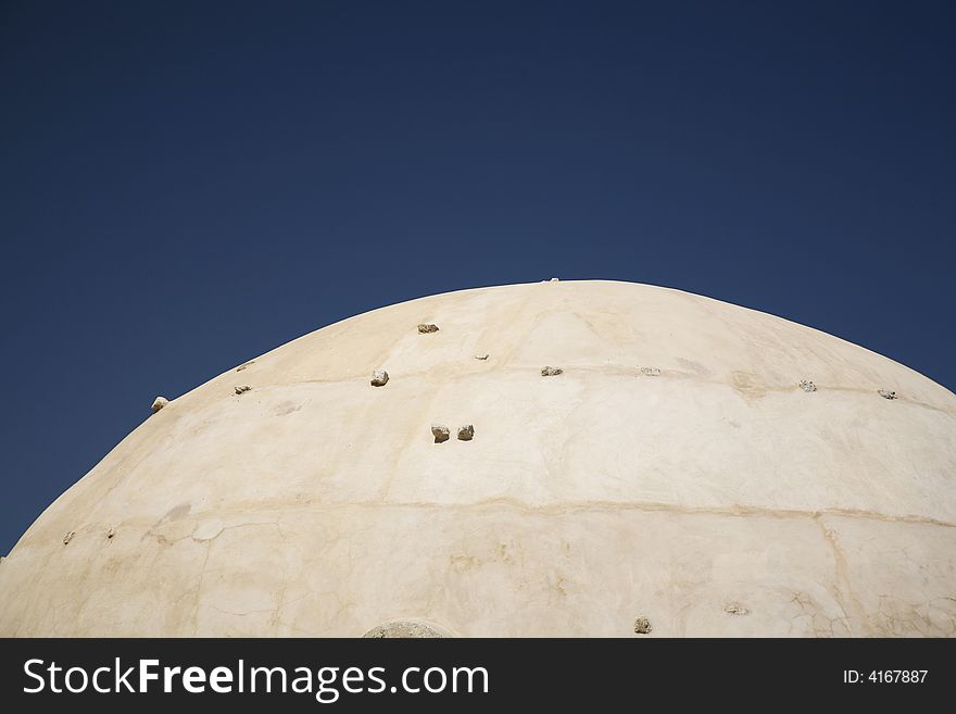 Pale cupola with stones and a dark blue sky