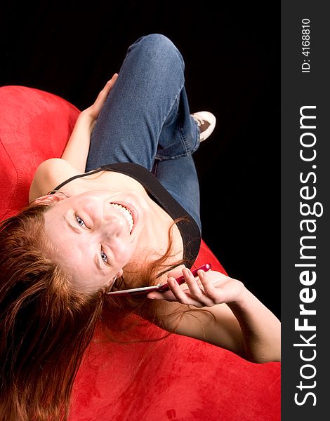 Redhead woman talking on cell phone upside down on couch. Redhead woman talking on cell phone upside down on couch.