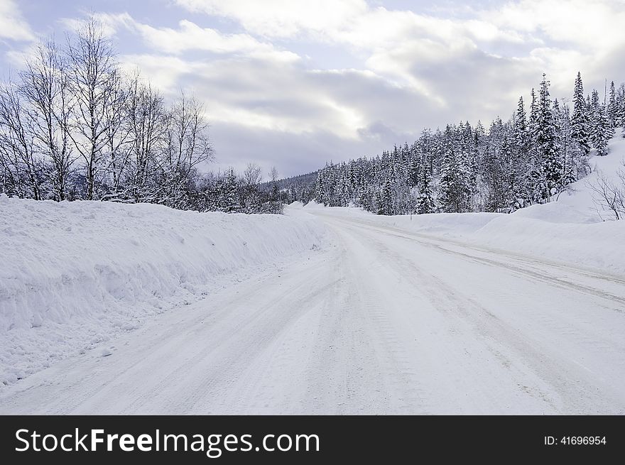 Winter road in Norway curving away in the distance.