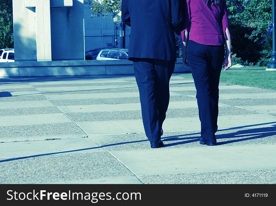 Rear view of businessman and businesswoman walking together towards building. Rear view of businessman and businesswoman walking together towards building