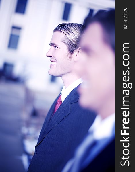 Two businessmen standing side to side in profile view