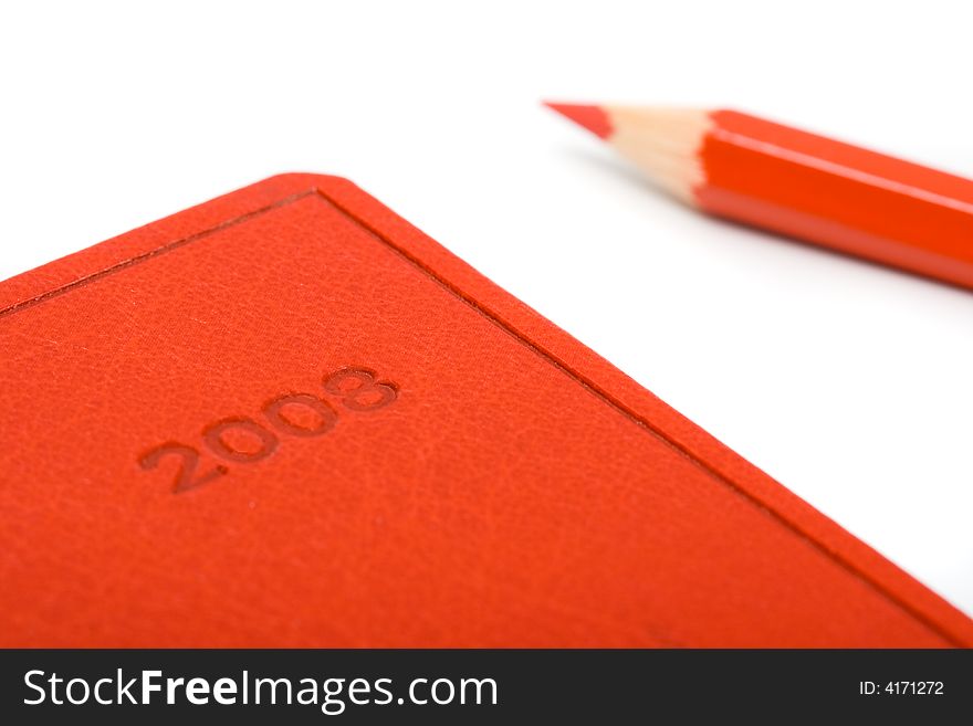 Isolated red notebook with pencil