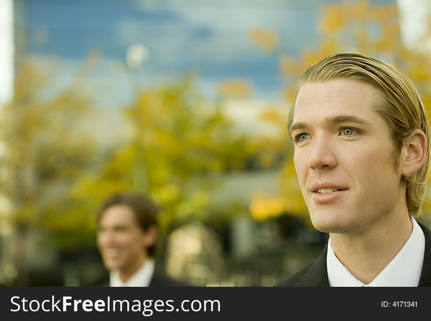 Head and shoulder view of two businessmen standing looking in same direction. Head and shoulder view of two businessmen standing looking in same direction