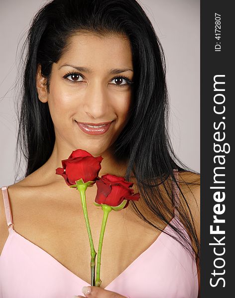 Pretty Indian girl holding two red roses. Pretty Indian girl holding two red roses.