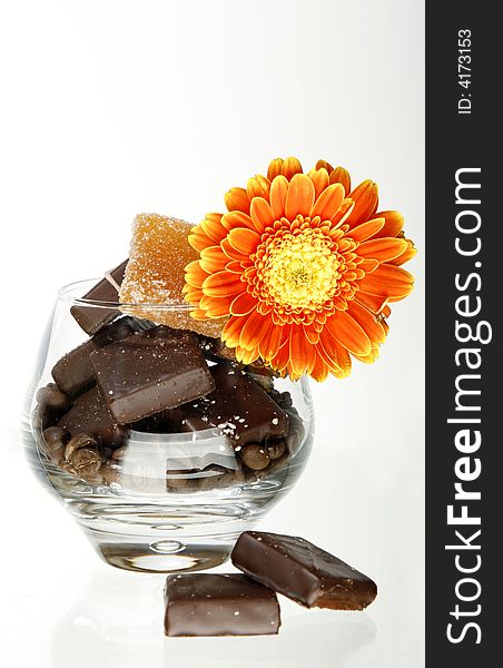 Vase with chocolate handmade sweets and orange gerber flower. Vase with chocolate handmade sweets and orange gerber flower