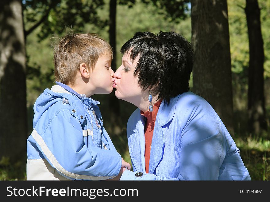 Beautiful young mother kisses her son