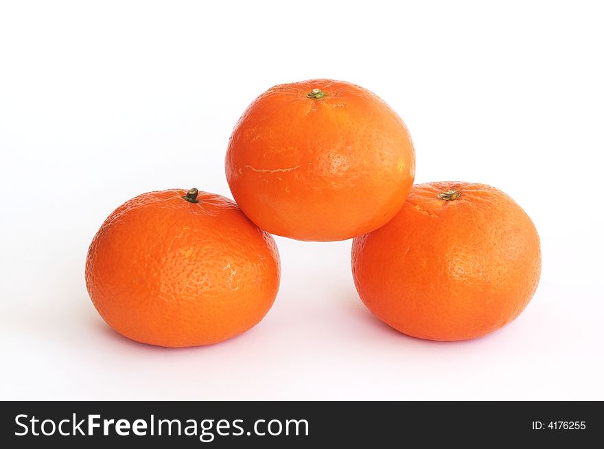 Pile of three orange tangerines isolated on white, horizontal.