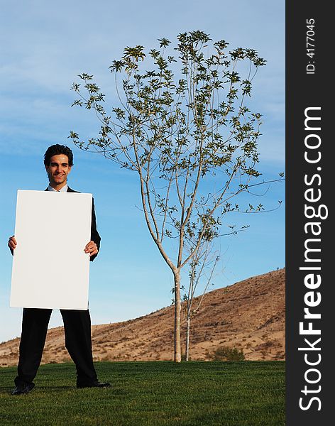 Businessman holding blank board