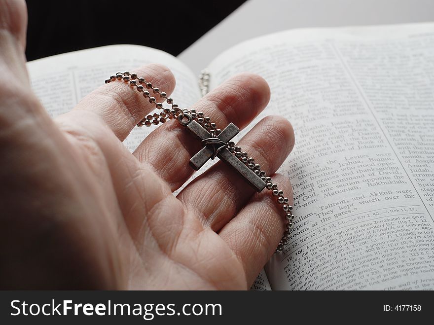 Holy bible open with a cross on a hand. Holy bible open with a cross on a hand