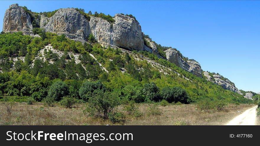 Panoramic Image of the Hill Covered by Green Forest and the Sandy Road. Panoramic Image of the Hill Covered by Green Forest and the Sandy Road