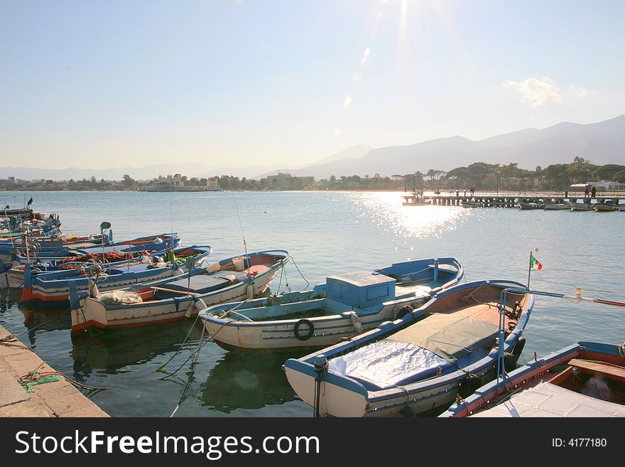 Colorful Sicilian boats on the dock in the port of Mondello, near Palermo. Coast line and beach. Sicily - Italy. Colorful Sicilian boats on the dock in the port of Mondello, near Palermo. Coast line and beach. Sicily - Italy