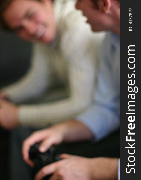 Two young men sitting down playing video games. Two young men sitting down playing video games