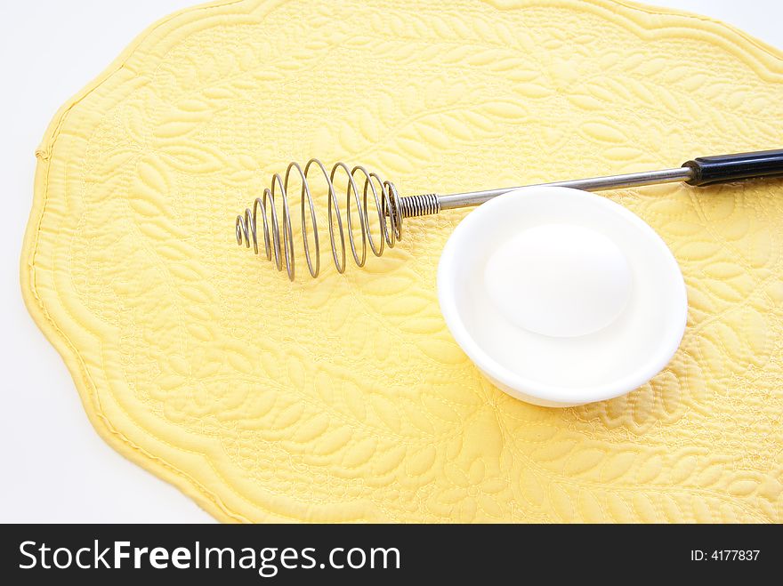 Whole white egg in bowl on yellow placemat. Whole white egg in bowl on yellow placemat