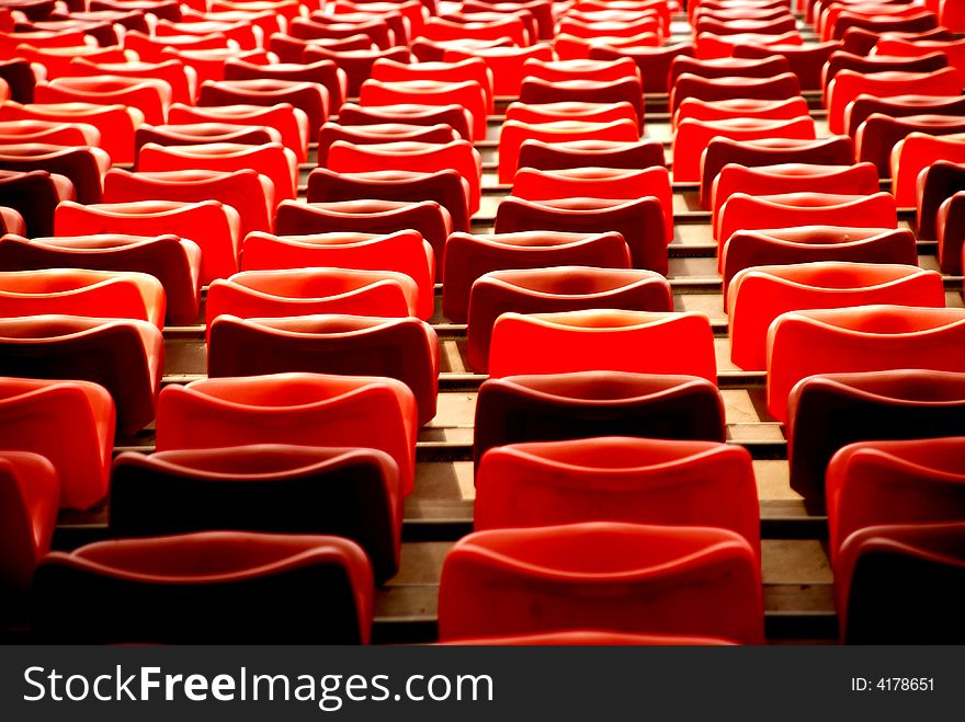 Diagonal lines ,concentrating lines,waves and curves formed by red plastic chairs in a stadium. Diagonal lines ,concentrating lines,waves and curves formed by red plastic chairs in a stadium.