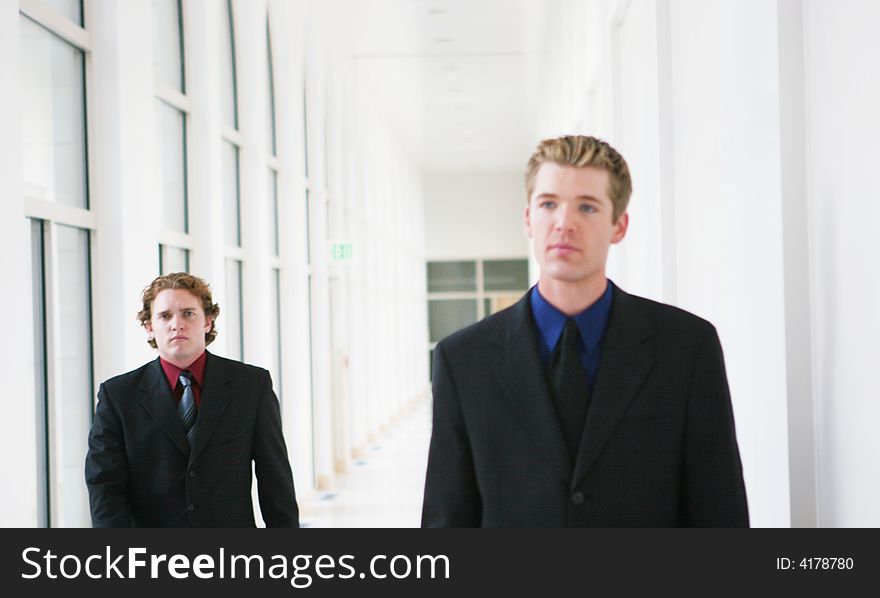 Two businessmen walking in hallway