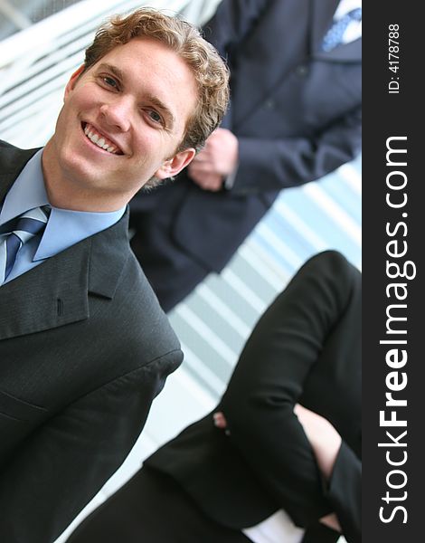 Three business people all looking forward standing on steps. Three business people all looking forward standing on steps