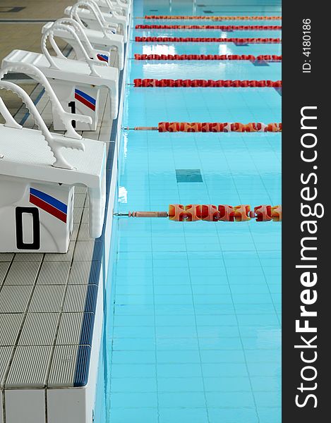 Starting blocks and empty lanes in an olympic size swimming pool. Starting blocks and empty lanes in an olympic size swimming pool