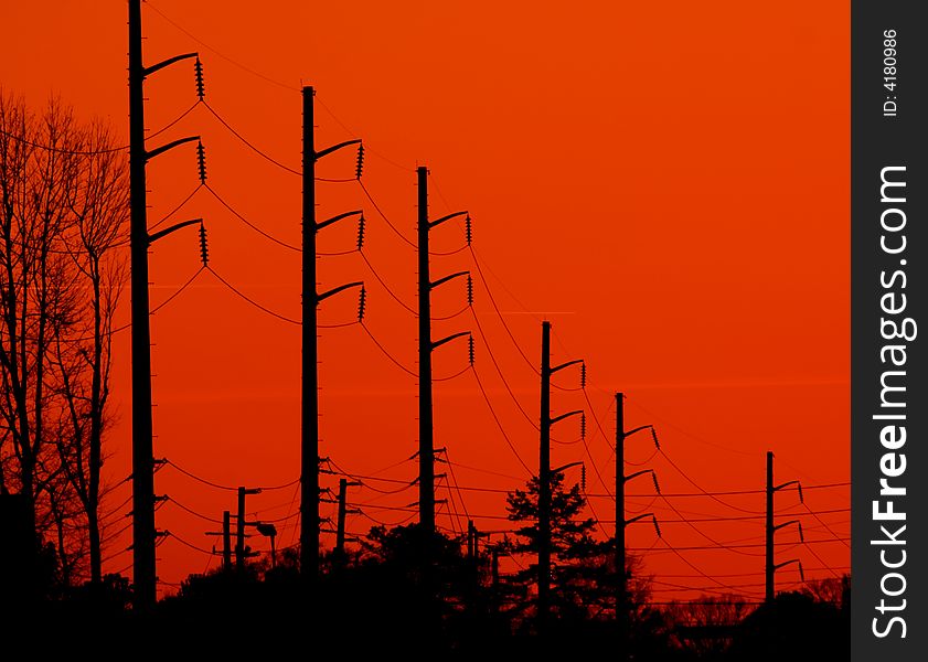 Power transmission lines silhouetted against a bright orange background. Power transmission lines silhouetted against a bright orange background