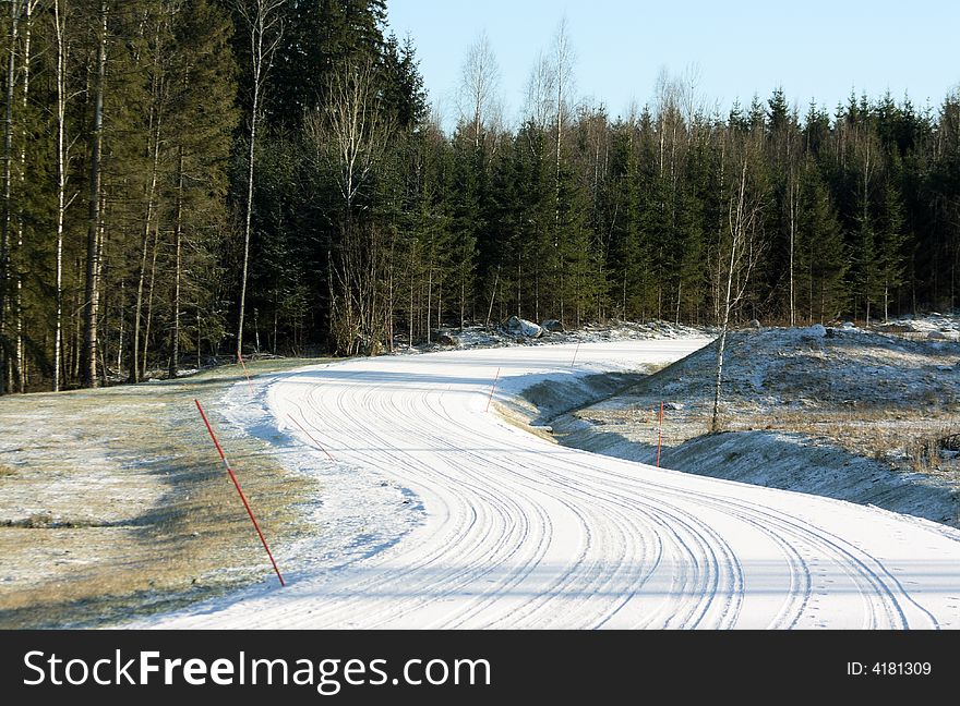 Snowy road with wheel tracks and a curve