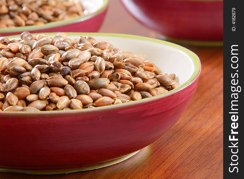 Several bowls of organic barley on wooden counter. Several bowls of organic barley on wooden counter.