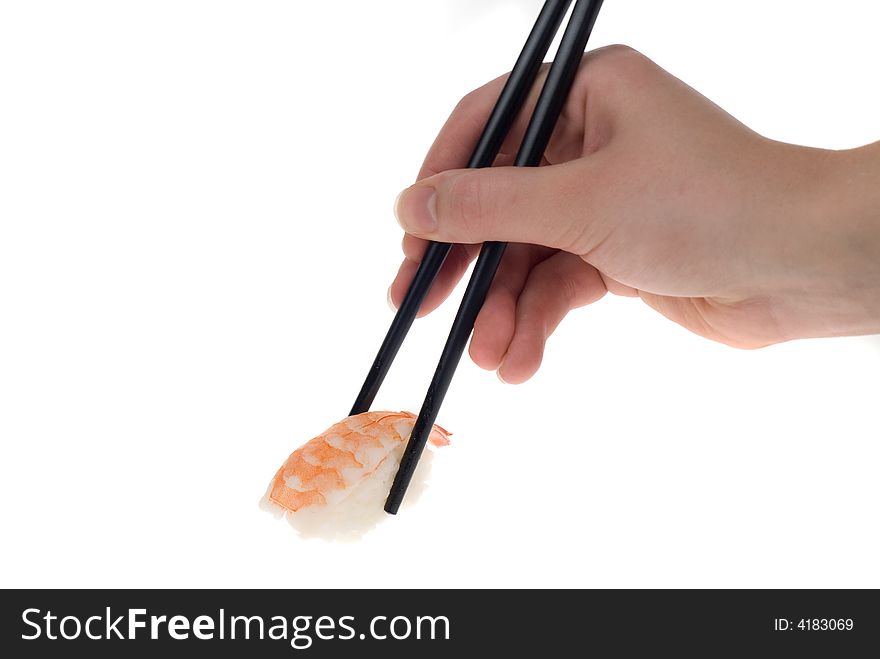 A hand with chopsticks picking up a piece of sushi isolated on white