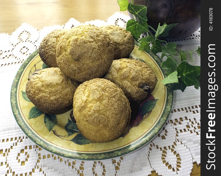 Plate of freshly baked chocolate chip muffins on lace table runner. Plate of freshly baked chocolate chip muffins on lace table runner