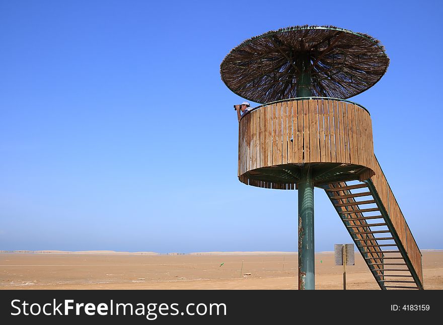 Man looking through binoculars in a birdwatching tower (Punta del Fangar, Ebro Delta,  Spain). Man looking through binoculars in a birdwatching tower (Punta del Fangar, Ebro Delta,  Spain)