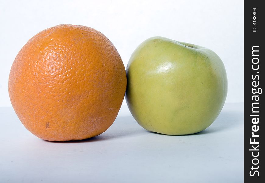 Orange and apple against a plain background. Orange and apple against a plain background