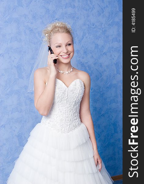 Smiling bride calling by phone